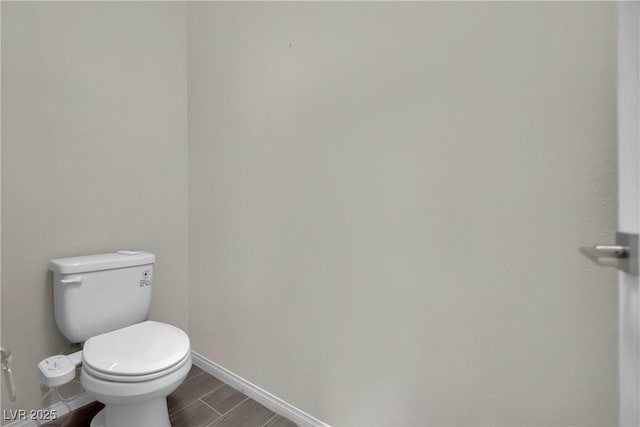 bathroom featuring baseboards, toilet, and wood finished floors