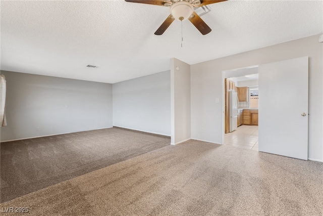 spare room with light colored carpet and a textured ceiling