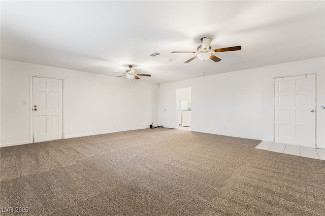 carpeted spare room featuring washer / clothes dryer and ceiling fan