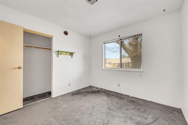 unfurnished bedroom with a textured ceiling and a closet