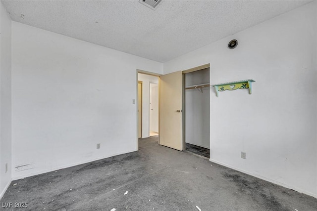 unfurnished bedroom featuring a textured ceiling and a closet