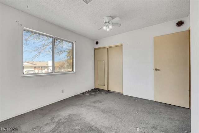 unfurnished bedroom with ceiling fan, a closet, carpet, and a textured ceiling