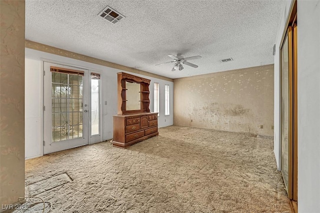 carpeted empty room with a textured ceiling and ceiling fan