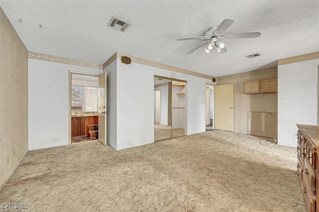 unfurnished living room with ceiling fan, light carpet, and a textured ceiling