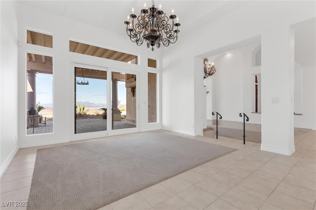 interior space with an inviting chandelier, light tile patterned flooring, and a high ceiling