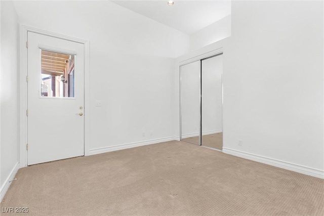 unfurnished bedroom featuring light carpet and a closet