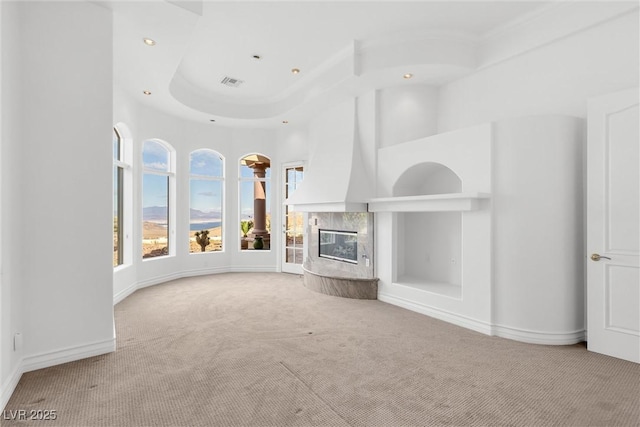 unfurnished living room with carpet floors, built in features, a fireplace, and a towering ceiling