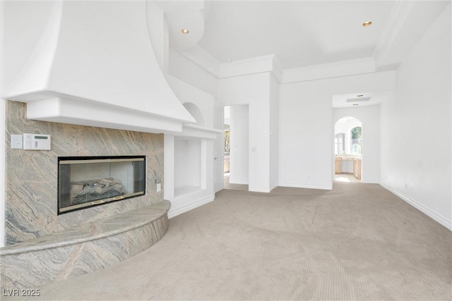 unfurnished living room featuring light colored carpet, ornamental molding, and a fireplace