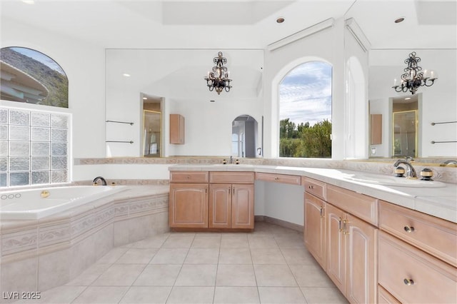 bathroom with independent shower and bath, vanity, tile patterned floors, and an inviting chandelier