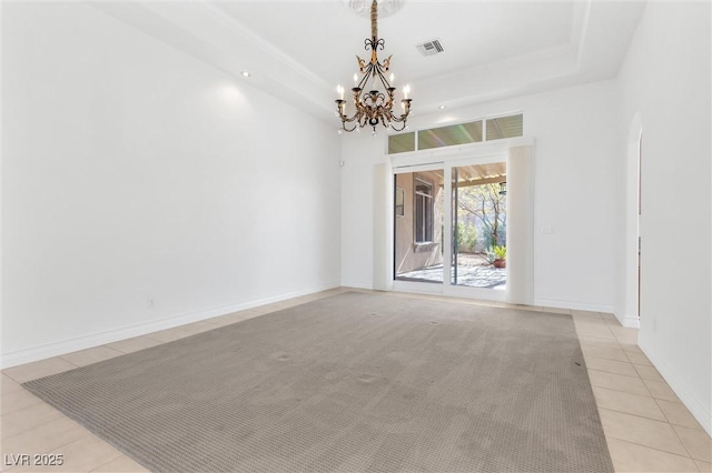 unfurnished room with an inviting chandelier, a tray ceiling, and light tile patterned flooring