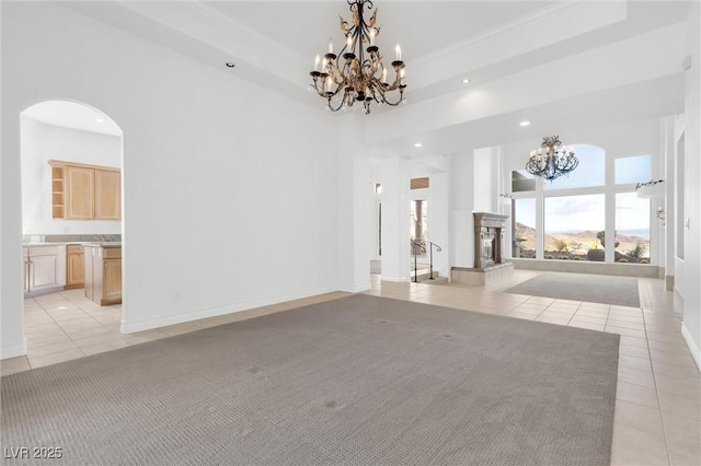 interior space featuring an inviting chandelier, light tile patterned floors, a tray ceiling, and a high ceiling