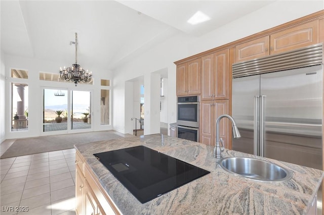 kitchen with light tile patterned flooring, lofted ceiling, sink, a center island with sink, and stainless steel appliances