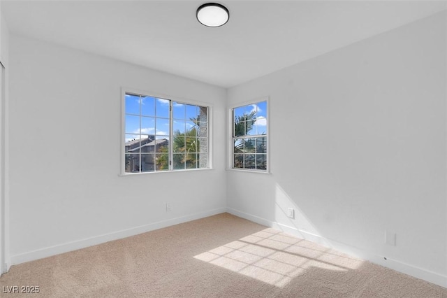empty room featuring baseboards and carpet flooring