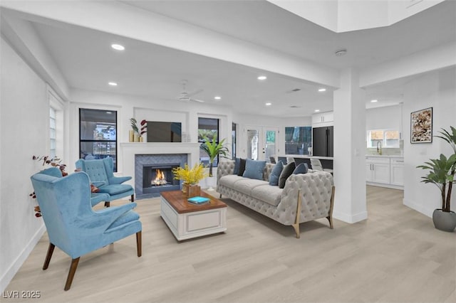 living room featuring french doors, sink, ceiling fan, and light hardwood / wood-style flooring