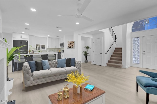 living room featuring ceiling fan and light hardwood / wood-style flooring