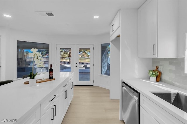 kitchen with white cabinetry, dishwasher, backsplash, light wood-type flooring, and french doors