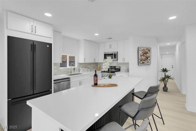 kitchen with stainless steel appliances, a center island, and white cabinets