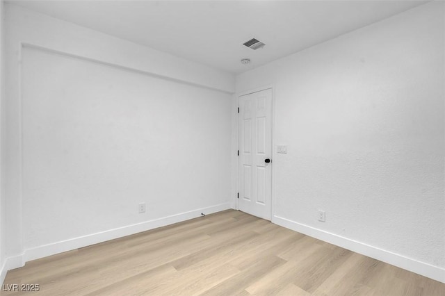 unfurnished room with baseboards, visible vents, and light wood-style flooring