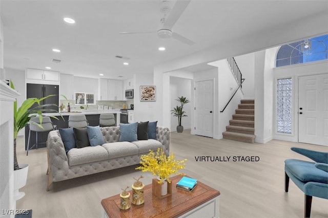 living area featuring stairway, light wood-style floors, and recessed lighting