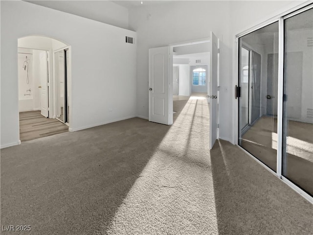 hallway with a high ceiling and carpet floors