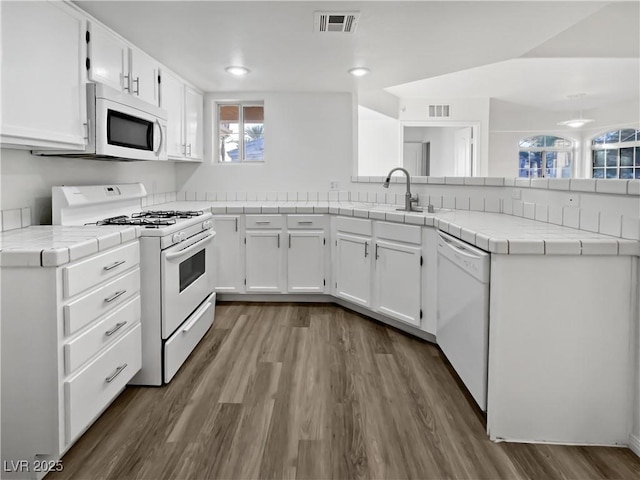 kitchen featuring white cabinetry, sink, tile counters, and white appliances