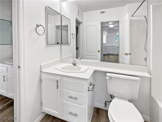 bathroom featuring wood-type flooring, toilet, and vanity