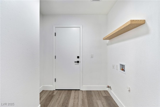 washroom featuring hookup for a gas dryer, washer hookup, and light hardwood / wood-style flooring