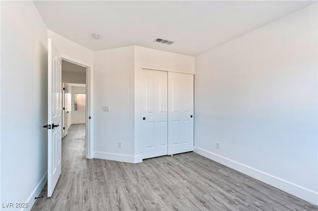 unfurnished bedroom featuring a closet and light hardwood / wood-style flooring