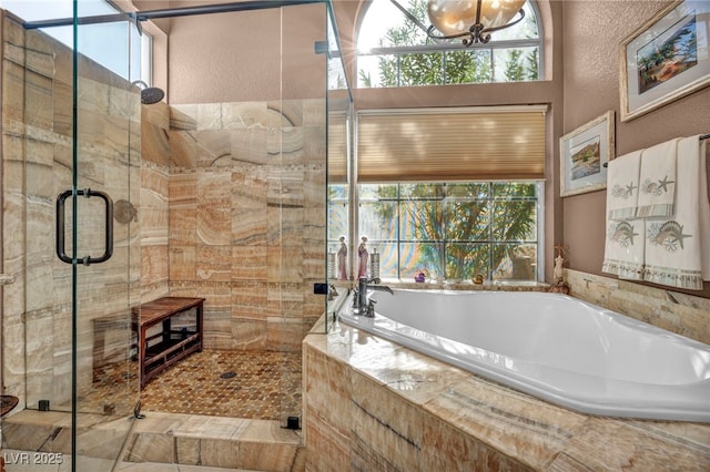 bathroom featuring plus walk in shower and a wealth of natural light