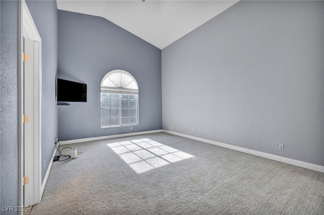 carpeted spare room with high vaulted ceiling