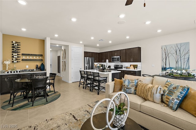 living room featuring light tile patterned floors and ceiling fan