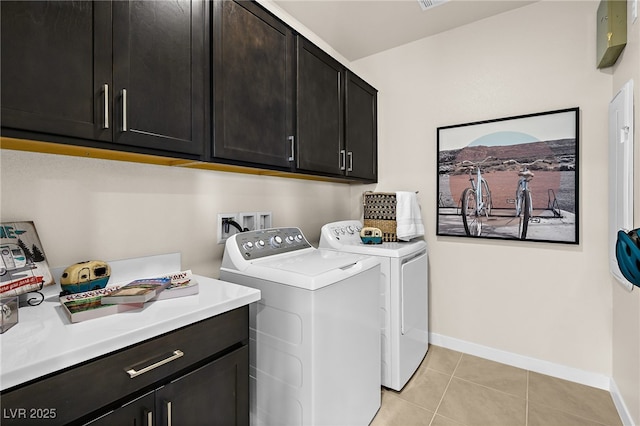 laundry area featuring light tile patterned flooring, cabinets, and independent washer and dryer