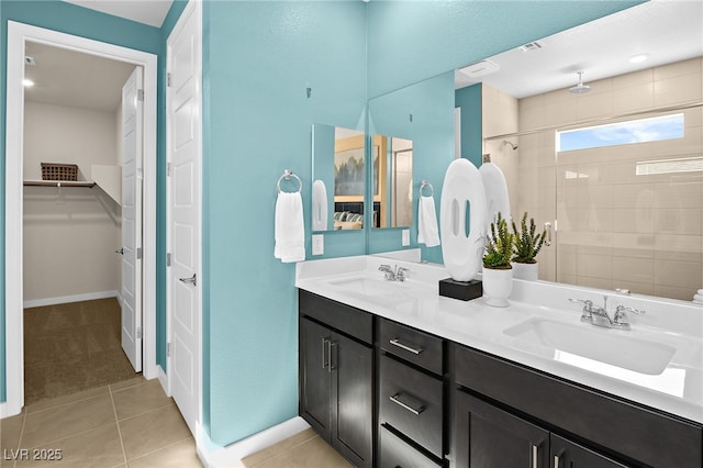 bathroom with tiled shower, vanity, and tile patterned floors