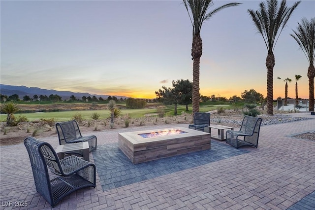 patio terrace at dusk with a mountain view and a fire pit