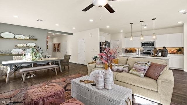 living room with dark hardwood / wood-style floors and ceiling fan