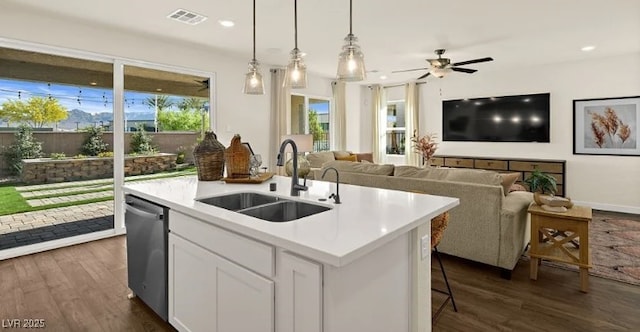 kitchen featuring sink, white cabinetry, a center island with sink, decorative light fixtures, and stainless steel dishwasher