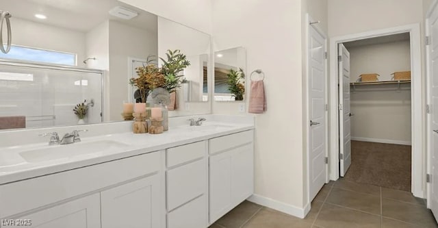 bathroom with tile patterned flooring, vanity, and a shower with door