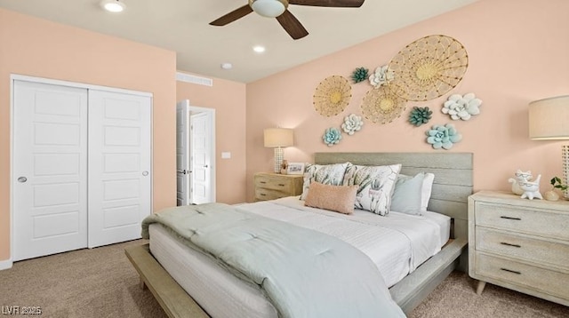 bedroom with ceiling fan, light colored carpet, and a closet