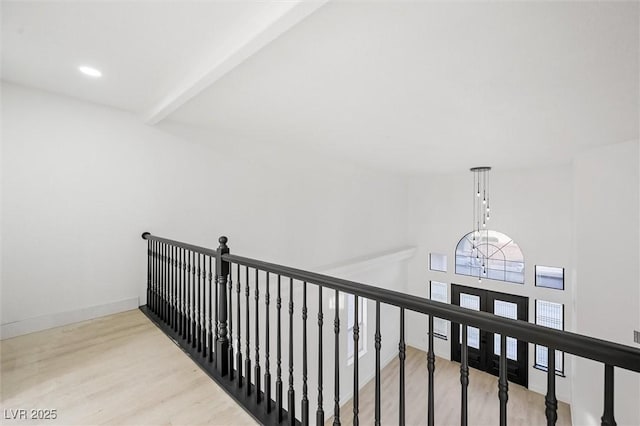 corridor featuring beamed ceiling and light hardwood / wood-style flooring