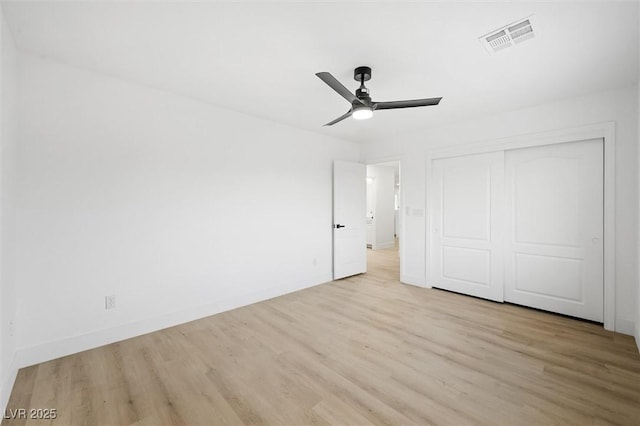 unfurnished bedroom featuring ceiling fan, a closet, and light hardwood / wood-style flooring