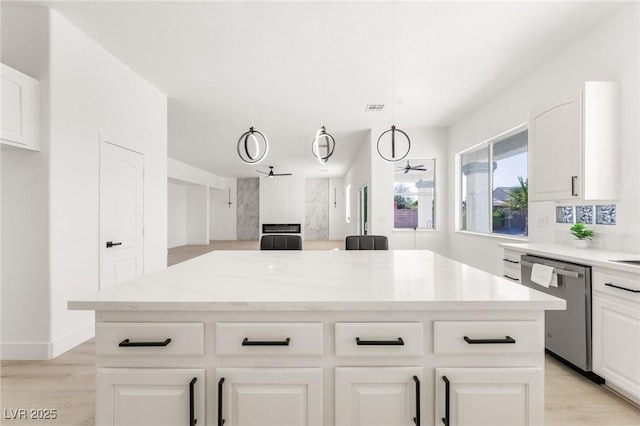 kitchen featuring white cabinetry, light stone counters, stainless steel dishwasher, a kitchen island, and pendant lighting