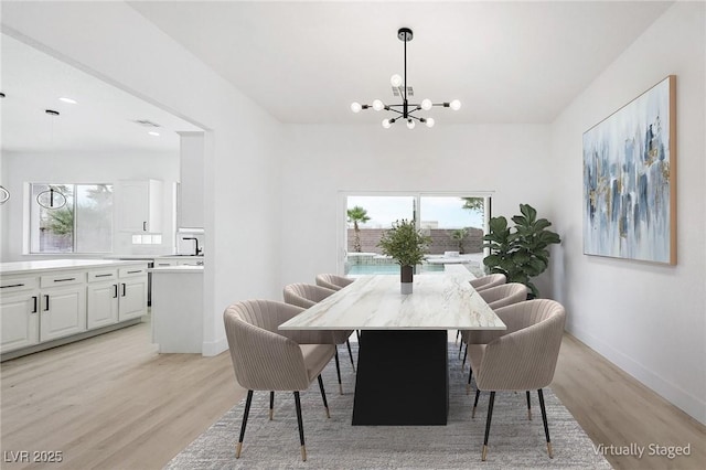 dining area with a chandelier and light wood-type flooring