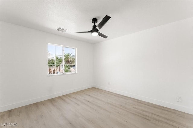 empty room with ceiling fan and light hardwood / wood-style floors