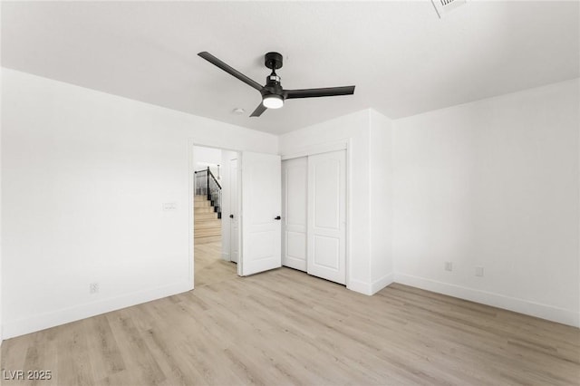 unfurnished bedroom featuring a closet, ceiling fan, ensuite bath, and light hardwood / wood-style flooring