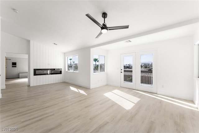 unfurnished living room featuring ceiling fan and light hardwood / wood-style floors