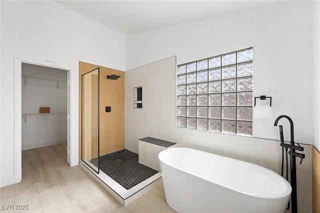 bathroom with wood-type flooring and plus walk in shower