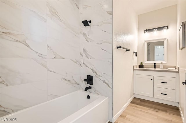 bathroom featuring vanity, hardwood / wood-style floors, and tiled shower / bath