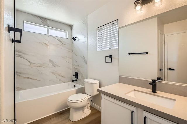 full bathroom featuring tiled shower / bath, vanity, toilet, and hardwood / wood-style floors