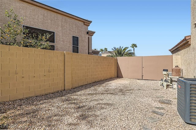 view of yard with central AC and a patio