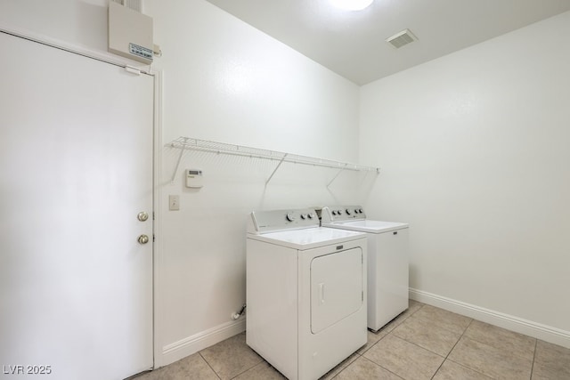 laundry area featuring light tile patterned flooring and washing machine and dryer